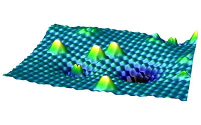 An STM image of the surface of titanium dioxide with different forms of oxygen. The higher, white peaks are oxygen molecules that are sitting on the surface, the smaller double peak in the foreground is an oxygen molecule that is already embedded. Image: M. Setvin et al. / AAAS