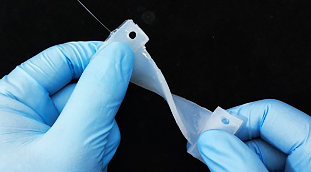 A flexible, skin-like sensor in gloved hands
