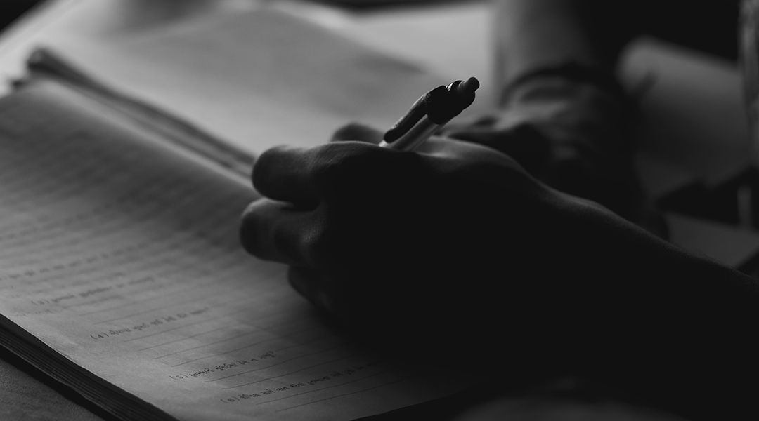 Hand writing in a notebook, black and white.