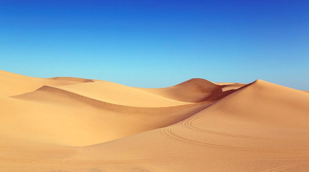 Sand dunes against a blue sky