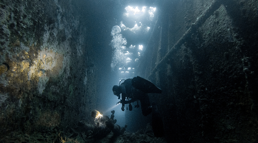 Diver exploring an underwater wreck.