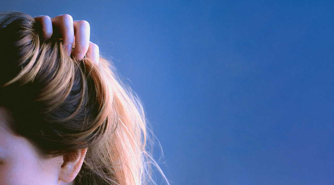 Woman holding her hair on a blue background