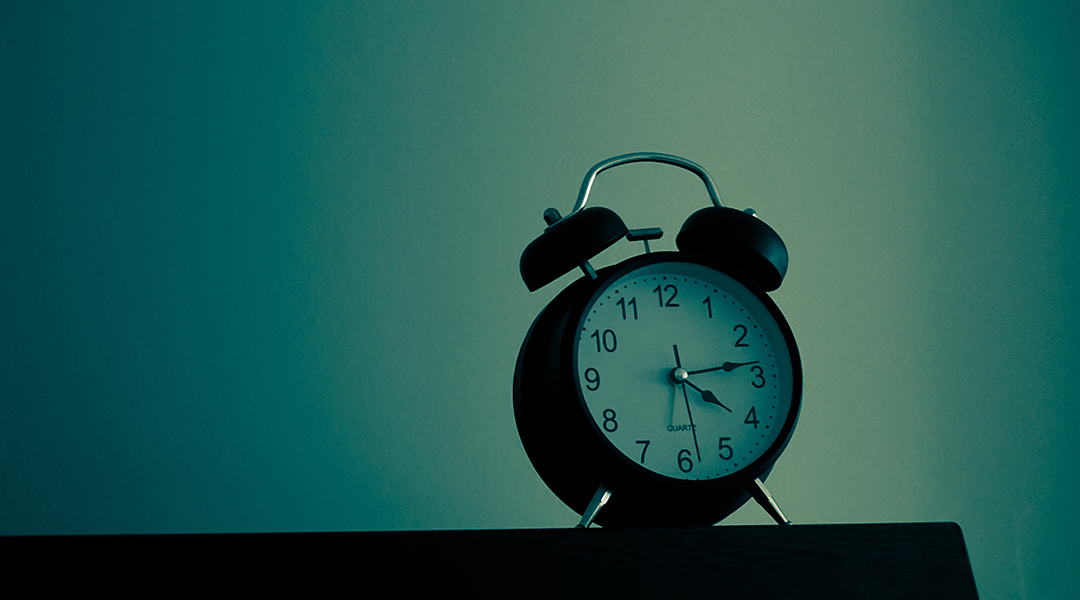 An alarm clock on a blue background.