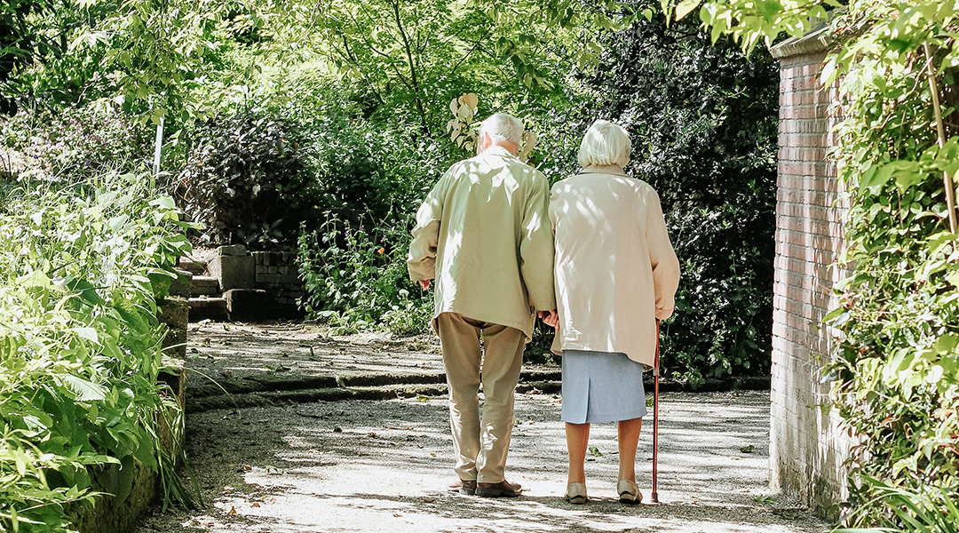 An elderly couple walking down a lane way.