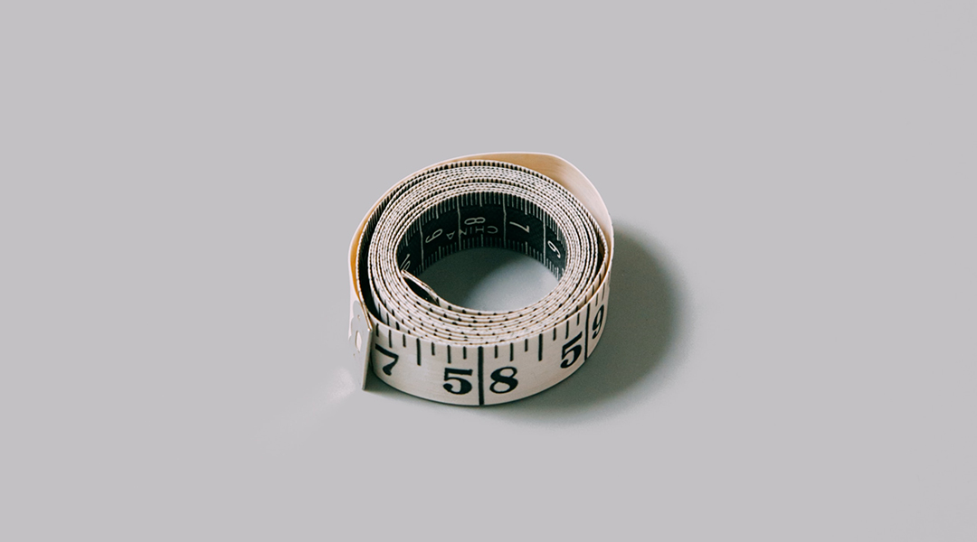 A measuring tape on a grey background.
