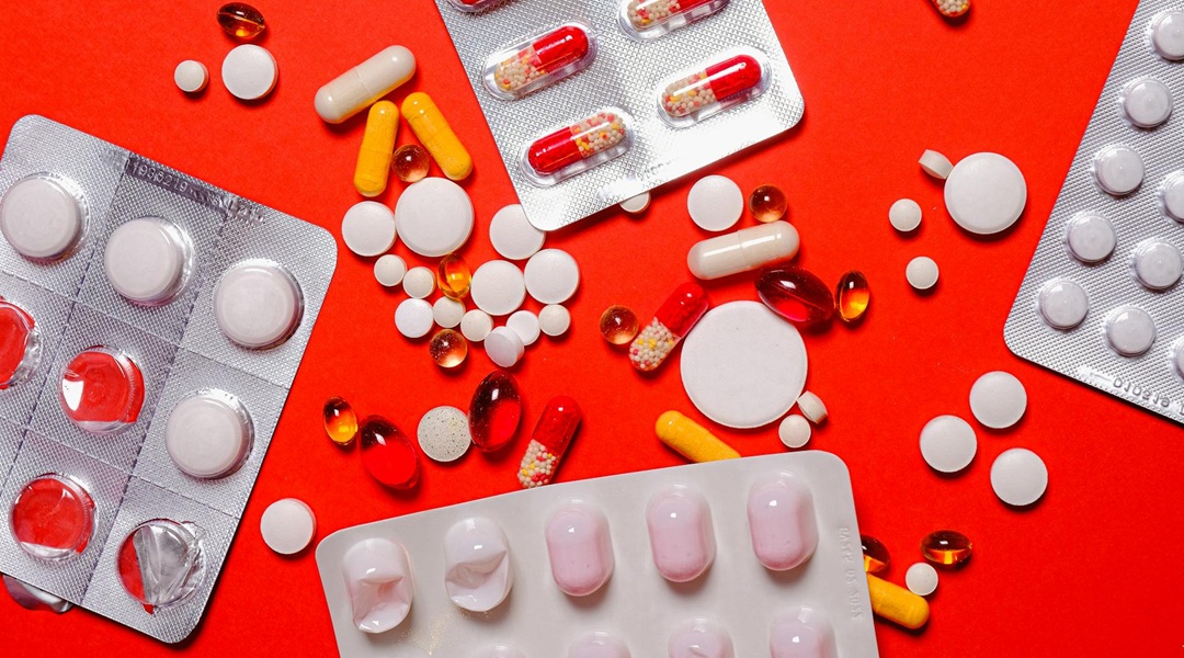 various pills on a red background