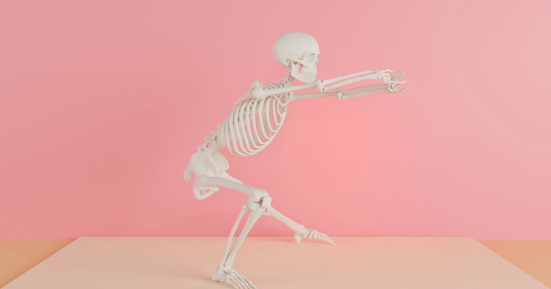 a skeleton stretching against a pink background