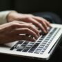hands hovering over a laptop keyboard