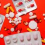various pills on a red background