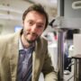 Professor Mulvihill, man, standing in a lab beside lab equipment.
